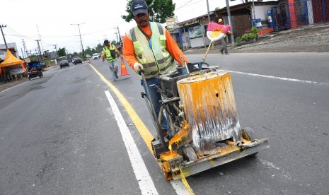 Pekerja mengecat marka jalan di Jalan Lintas Sumatera (Jalinsum) Tanjung Morawa, Kabupaten Deliserdang, Sumatera Utara, Kamis (16/5/2019). 