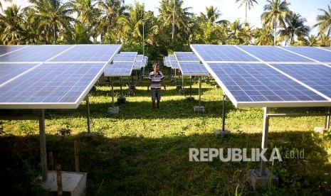 Pekerja mengecekan terhadap panel surya di pembangkit Listrik Tenag Surya di Pulau Minagas, Sulut, Senin (18/4).