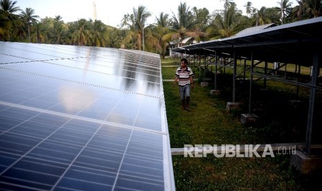 Pekerja mengecekan terhadap panel surya di pembangkit Listrik Tenag Surya di Pulau Minagas, Sulut, Senin (18/4).