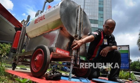 Pekerja mengeluarkan bensin usai melakukan pengukuran liter di SPBU, Jakarta, Rabu (17/2).