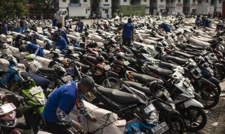 Pekerja mengepak sepeda motor milik pemudik peserta program Angkutan Motor Gratis 2018 di Stasiun Jakarta Gudang, Kampung Bandan, Jakarta, Jumat (8/6).