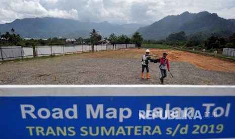 Pekerja mengerjakan pemasangan patok BM (benchmark) untuk acuan koordinat pada proyek Jalan Tol Sumbar-Riau, di Jalan Bypass KM 25, Padangpariaman, Sumatra Barat, Selasa (3/4). Berdasarkan data Dinas PU Sumbar pembangunan jalan tol yang menghubungkan Sumbar-Riau sepanjang 244 kilometer itu masih menunggu penyelesaian administrasi dari Badan Pertanahan Nasional.