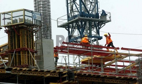 Pekerja mengerjakan pembangunan gedung bertingkat di Jakarta, Rabu (19/2).