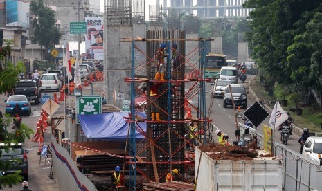 Pekerja mengerjakan pembangunan proyek kereta api ringan / Light Rail Transit (LRT) di zona tiga di jalan Kol H Barlian, Palembang, Sumatera Selatan, Rabu (16/3).