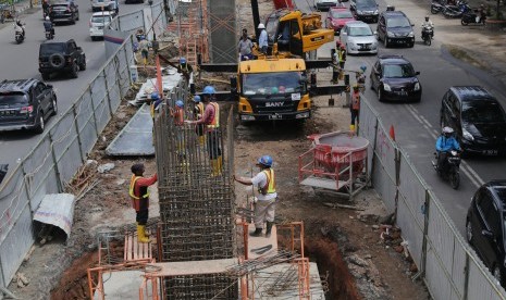 Pekerja mengerjakan pembangunan proyek kereta api ringan/Light Rail Transit (LRT) di jalan Jenderal Sudirman, Palembang, Sumatera Selatan, Senin (28/3).