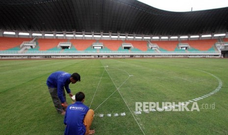 Pekerja mengerjakan perawatan rumput lapangan Stadion Pakansari di Bogor, Jawa Barat, Rabu (23/5).