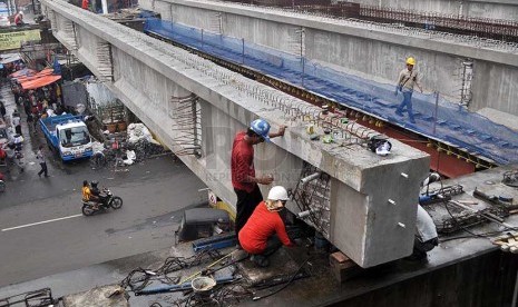 Pekerja mengerjakan proyek jembatan penghubung di Pasar Tanah Abang, Jakarta Pusat, Kamis (27/2).  (Republika/Rakhmawaty La'lang)