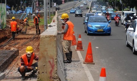 Pekerja mengerjakan proyek pelebaran jalan di depan Mal Cassablanca, Jakarta Selatan, Jumat (14/2). (Republika/Rakhmawaty La'lang)