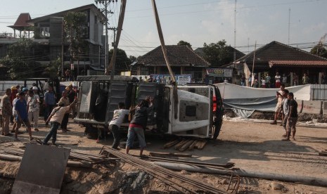 Pekerja mengevakuasi mobil yang terperosok di proyek underpass Kentungan yang ambles, Sleman, DI Yogyakarta, Selasa (23/7/2019). Galian proyek pembangunan underpass Kentungan ambles dan mengakibatkan satu truk dan mobil Land Rover milik wisatawan asal Australia terperosok, tidak ada korban dalam kejadian tersebut. 