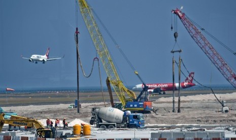 Pekerja menggarap pembangunan apron timur Bandara Internasional I Gusti Ngurah Rai, Kuta, Bali, Jumat (20/7).