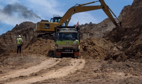 Pekerja menggunakan alat berat mengerjakan proyek pembangunan jalan tol Serang-Panimbang di Desa Mandala, Lebak, Banten, Senin (11/2/2019). 