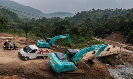 Pekerja menggunakan alat berat menyelesaikan perbaikan jalan di Lebak Gedong, Lebak, Banten, Sabtu (2/10/2021). Pemprov Banten melakukan perbaikan jalan nasional penghubung antar provinsi sepanjang 9 kilometer serta 5 jembatan di Lebak yang sebelumnya rusak akibat longsor pada tahun lalu dan ditargetkan selesai pada akhir Desember 2021. 