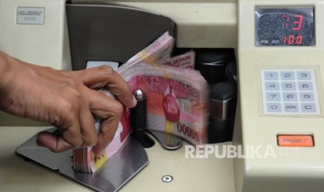  Pekerja menghitung uang rupiah di salah satu tempat penukaran, Jakarta, Jumat (2\12).