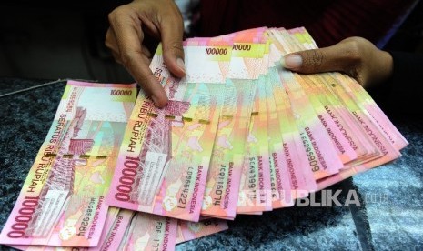  Pekerja menghitung uang rupiah di salah satu tempat penukaran uang. ilustrasi