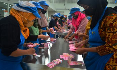 Pekerja menghitung uang Tunjangan Hari Raya (THR) yang diterimanya di pabrik rokok PT Djarum, Kudus, Jawa Tengah, Selasa (19/4/2022). Sebanyak 52.025 pekerja harian dan borongan yang tersebar di tujuh kota di perusahaan itu telah menerima uang THR guna membantu mereka dalam memenuhi kebutuhan keluarga selama bulan Ramadhan dan Idul Fitri. 