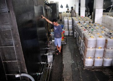 Pekerja mengisi jeriken minyak goreng curah di Pasar Tanah Abang, Jakarta, Rabu (11/1). (Republika/Wihdan Hidayat)