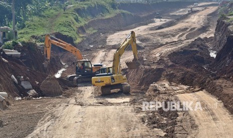 Pekerja mengoperasikan alat berat dalam pembangunan Tol Semarang-Batang di Ngaliyan, Semarang, Jawa Tengah, Kamis (3/5). 