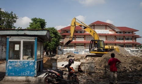 Pekerja mengoperasikan alat berat membongkar bangunan Pasar Klewer sisi timur, Solo, Jawa Tengah, Senin (4/12). 