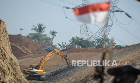 Pekerja mengoperasikan alat berat pada proyek jalan tol. Negara dapat menggunakan tanah wakaf untuk PSN dan memberikan penggantinya. Ilustrasi.