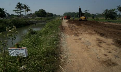 Pekerja mengoperasikan alat berat saat proses pengerasan tanah di lokasi pembangunan Tol Yogyakarta-Bawen Seksi 1 di Seyegan, Sleman, D.I Yogyakarta, Rabu (27/7/2022). Jalan Tol Yogyakarta-Bawen nantinya akan memiliki panjang 76 kilometer membentang dari Sleman hingga Bawen.