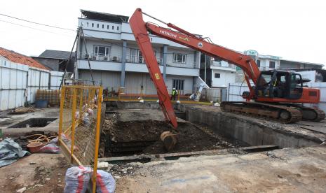 Pekerja mengoperasikan alat berat untuk memeriksa proyek pembangunan sodetan Kali Ciliwung ke Kanal Banjir Timur (KBT) di Jakarta, Senin (16/5/2022). Pengerjaan sodetan Kali Ciliwung ke Kanal Banjir Timur (KBT) melalui Kali Cipinang kini memasuki tahap penyelesaian pengeboran untuk pipa kedua di pintu keluar atau outlet ke Kali Cipinang untuk mengatasi air Kali Ciliwung yang kerap meluap saat hujan.