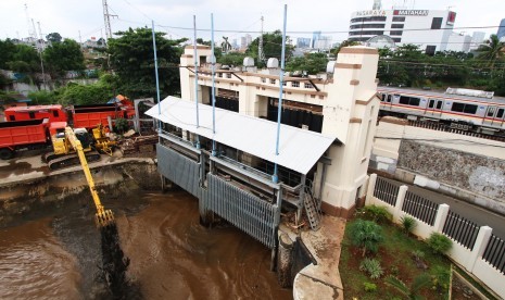 Pekerja mengoperasikan alat berat untuk mengeruk sampah di Pintu Air Manggarai, Jakarta, Kamis (3/3).