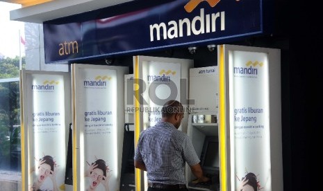  Pekerja mengunakan fasilitas pelayanan di ATM Bank Mandiri, Jakarta, Senin (19/10). 