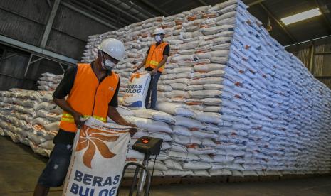 Pekerja menimbang karung beras di Gudang Perum Bulog Divre DKI Jakarta dan Banten, Kelapa Gading, Jakarta.