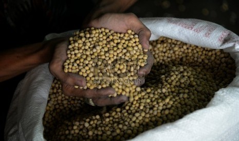 Pekerja menimbang kedelai ke dalam karung di sebuah gudang penyimpanan di Jakarta, Rabu (28/1). (Republika/Prayogi)