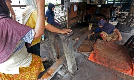 Pekerja menumbuk biji kopi jenis robusta dengan alat penumbuk tradisional (Jengki) di salah satu tempat produksi pengolahan  bubuk kopi di Desa Ie Masen, Kecamatan Ulee Kareng, Banda Aceh, Aceh, Rabu (17/2)