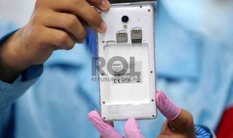  Pekerja menunjukan Smartphone OPPO yang bertuliskan 