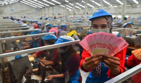 Pekerja menunjukkan uang Tunjangan Hari Raya (THR) yang diterimanya di pabrik rokok PT Djarum, Kudus, Jawa Tengah, Selasa (19/4/2022). Sebanyak 52.025 pekerja harian dan borongan yang tersebar di tujuh kota di perusahaan itu telah menerima uang THR guna membantu mereka dalam memenuhi kebutuhan keluarga selama bulan Ramadhan dan Idul Fitri.