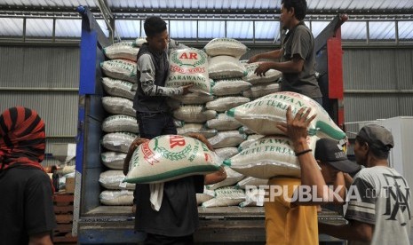 Pekerja menurunkan karung berisi beras kualitas premium dari truk di Gudang Bulog Sub Divisi Regional Serang, Banten, Jumat (2/8/2019).