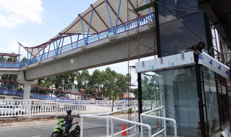 Pekerja menyelesaikan Jembatan Penyeberangan Orang (JPO) bernuansa Betawi di Jalan Tubagus Angke, Jakarta, Minggu (16/12/2018).