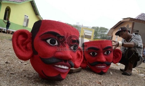   Pekerja menyelesaikan patung ondel-ondel Betawi di lokasi Festival Lebaran Betawi VIII, di Lapangan Banteng, Jakarta, Kamis (20/8).