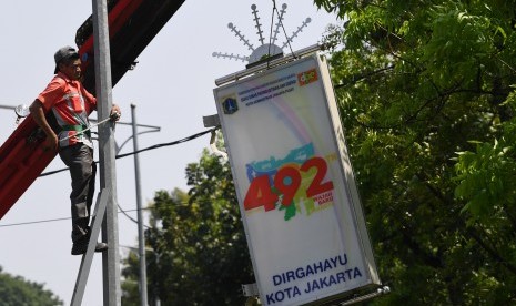 Pekerja menyelesaikan pemasangan lampu penerangan hias jelang HUT ke-492 Jakarta di jalan Medan Merdeka Utara Jakarta, Rabu (19/6/2019). 