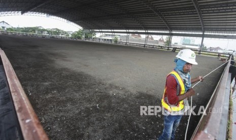 Pekerja menyelesaikan pembangunan arena Pacuan Kuda atau Equestrian di Jakarta Internasional Equestrian Park Pulomas (JIEPP), Pulomas, Jakarta, Kamis (8/3).