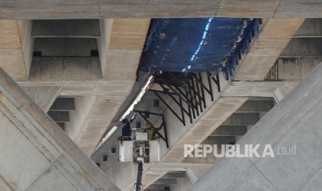  Pekerja menyelesaikan pembangunan tol JORR Tanjung Priok-Cilincing, Jakarta, Ahad (9/10). 