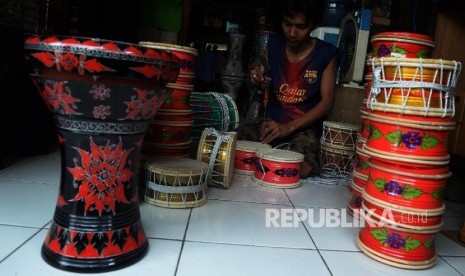 Pekerja menyelesaikan pembuatan alat musik marawis di bengkel pembuatan alat musik Islam di Cipinang Besar Selatan, Jakarta Timur, Senin (26/12).