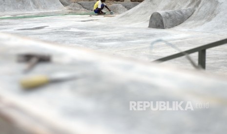 Pekerja menyelesaikan pembuatan arena permainan bmx dan skateboard di lahan bekas Kalijodo, Jakarta, Selasa (29/11)