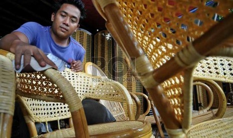 Pekerja menyelesaikan pembuatan mebel rotan tahap akhir di salah satu pusat usaha penjualan mebel rotan di Jakarta, Senin (11/8). 