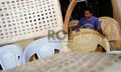 Pekerja menyelesaikan pembuatan mebel rotan tahap akhir di salah satu pusat usaha penjualan mebel rotan di Jakarta, Senin (11/8). 