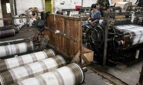 Pekerja menyelesaikan pembuatan sarung tenun khas Majalaya di pabrik HJ, Ai, Majalaya, Kabupaten Bandung, Jawa Barat, Kamis (17/5). 