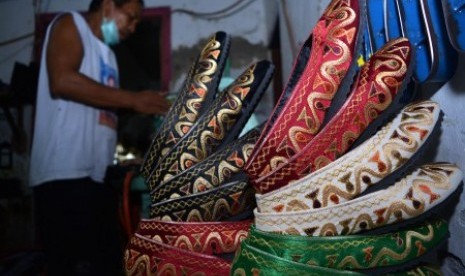 Pekerja menyelesaikan pembuatan sepatu bordir di industri rumahan kawasan Kampung batik Jetis, Sidoarjo, Jawa Timur, Rabu (23/12).