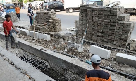 Pekerja menyelesaikan perbaikan saluran air di Jalan Sabang, Jakarta Pusat, Rabu (11/11).     (Republika/Yasin Habibi)