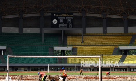 Pekerja menyelesaikan pergantian rumput lapangan Stadion Patriot Candrabhaga, di Bekasi, Jawa Barat, Selasa (20/2).