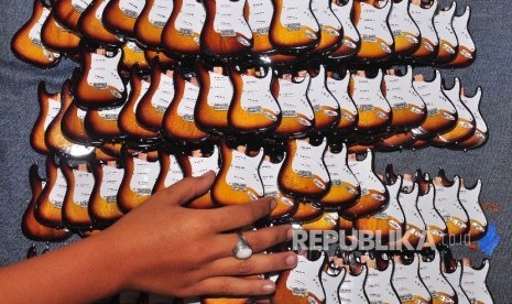 Pekerja menyelesaikan proses pemasangan aksesoris pada miniatur body gitar di Turasan, Manjungan, Ngawen, Klaten, Jawa Tengah, beberapa waktu lalu. ANTARA FOTO/Aloysius Jarot Nugroho/kye/15.