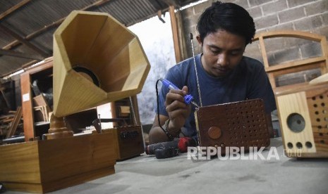 Pekerja menyelesaikan proses pembuatan radio kayu di workshop Kai Wooden Art, Jalan Tampomas, Kota Bandung, Selasa (2/7). Penyaluran KUR tahun 2019, sampai dengan 31 Mei 2019 sudah mencapai Rp 65,5 triliun, atau sekitar 47 persen dari target tahun 2019 sebesar Rp 140 triliun. 