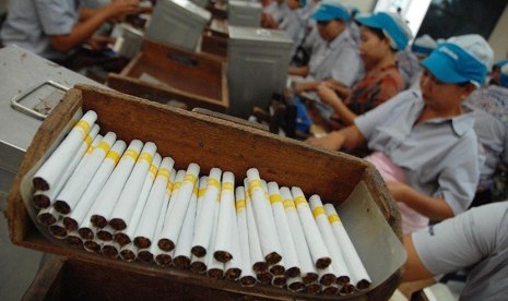 Pekerja menyelesaikan proses pembuatan rokok kretek.