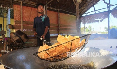 Pekerja menyelesaikan proses penggorengan kerupuk di salah satu sentra produksi kerupuk rumahan Desa Suak Ribe, Johan Pahlawan, Aceh Barat, Aceh, Senin (25/2).Otoritas Jasa Keuangan (OJK) mewajibkan seluruh fintech peer-to-peer (P2P) lending untuk menyalurkan 25 persen pembiayaan ke sektor produksi. 